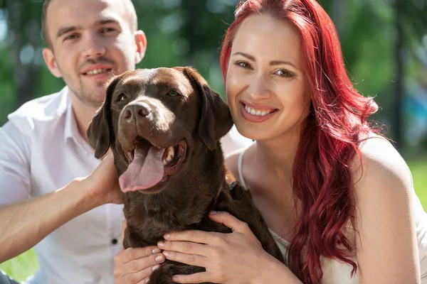 Casal com um cão no parque — Fotografia de Stock