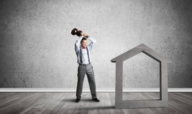 Taştan ev silueti, emlak sigortasının sembolü olarak boş odada.