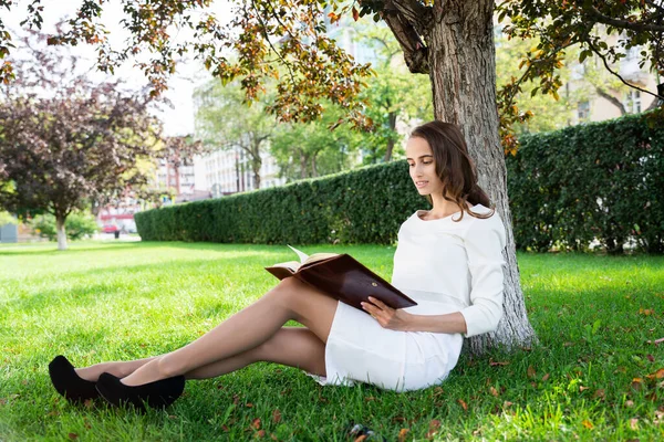 Bella giovane donna con blocco note nel parco — Foto Stock