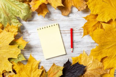 Spiral not defteri ve kalem eski ahşap masanın üzerinde.