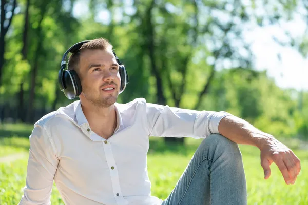Homem no parque ouve música — Fotografia de Stock