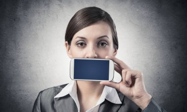 Ağzını akıllı telefonla kapatan kadın.