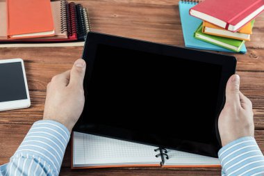Tabletli bir işadamı, ofiste çalışıyor.