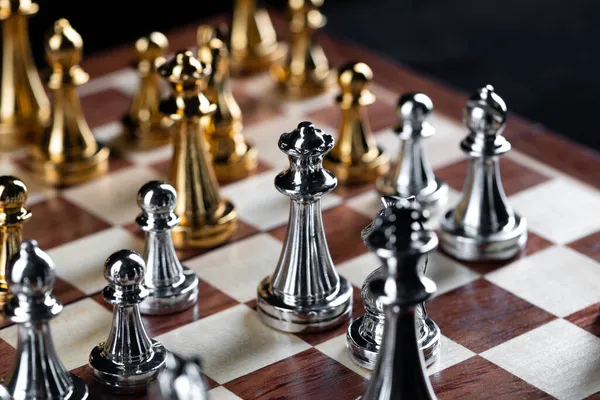 Ouro e prata figuras de xadrez colocados no tabuleiro de xadrez — Fotografia de Stock