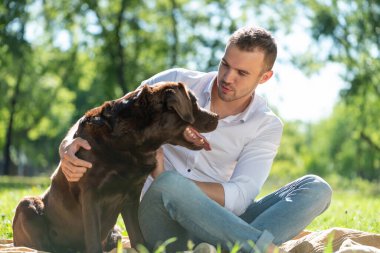 Parkta köpeği olan genç bir adam.