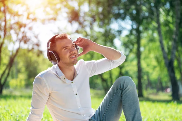 Muž v parku poslouchá hudbu — Stock fotografie