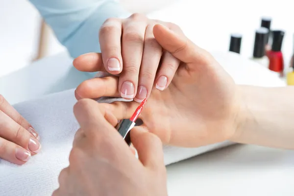 Vrouw ontvangt manicure door nagel schoonheidsspecialiste — Stockfoto