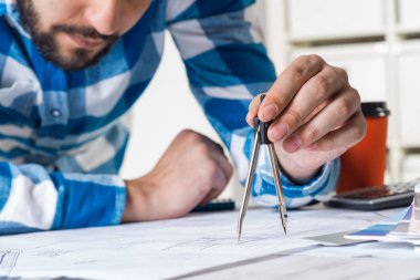 Planda pusula bölücüsüyle ölçüm yapan adam