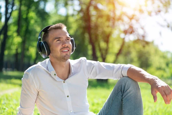 Muž v parku poslouchá hudbu — Stock fotografie