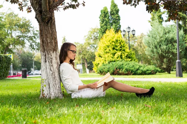 Vacker ung kvinna med anteckningsblock i parken — Stockfoto