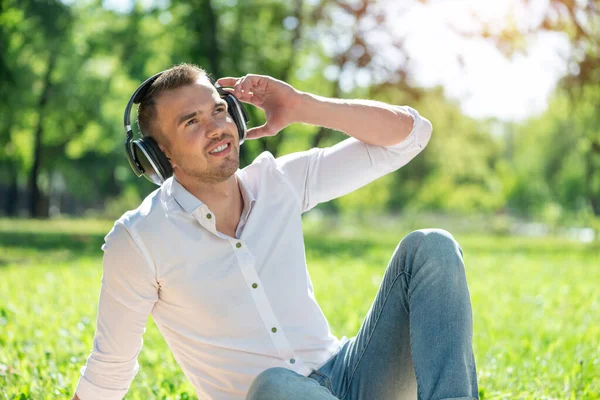 Człowiek w parku słucha muzyki. — Zdjęcie stockowe