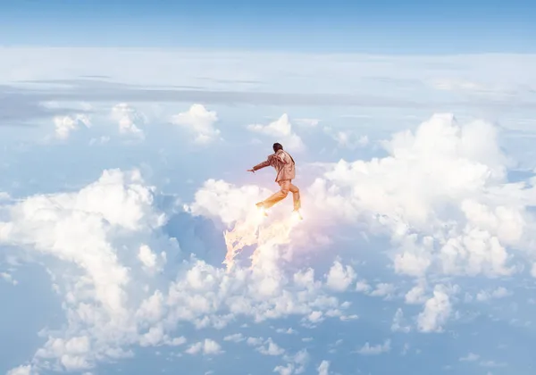 Takım elbiseli ve havacı şapkalı bir iş adamı gökyüzünde uçuyor. — Stok fotoğraf