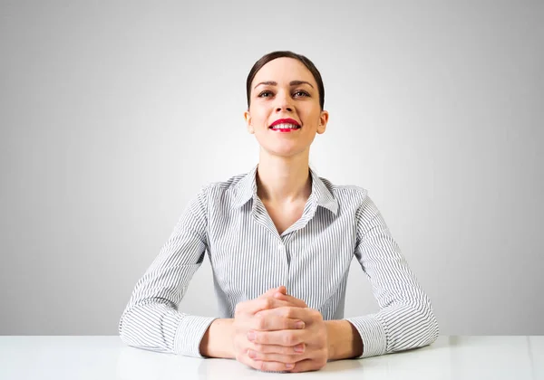 Uśmiechnięta bizneswoman siedząca przy biurku — Zdjęcie stockowe