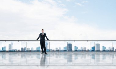 Gökdelenlerin üzerinde gün doğumu ve yeni bir güne bakan iş adamı