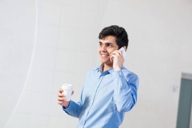 Genç işadamı cep telefonuyla konuşuyor.