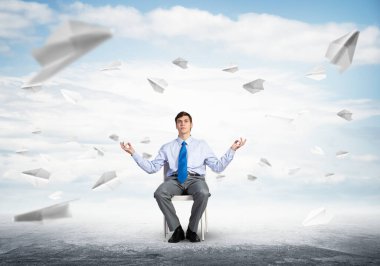 İş adamı ofis sandalyesinde meditasyon yapıyor.