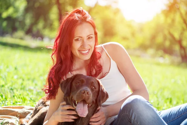 Młoda atrakcyjna kobieta przytula swojego psa w parku. — Zdjęcie stockowe