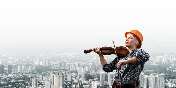 Belle femme en casque de sécurité jouant du violon — Photo