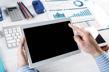 Tabletli bir işadamı, ofiste çalışıyor.