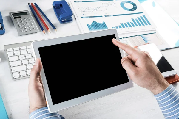 Tabletli bir işadamı, ofiste çalışıyor.