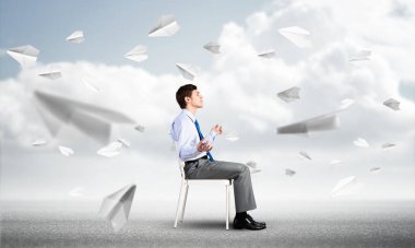 İş adamı ofis sandalyesinde meditasyon yapıyor.