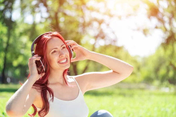 Una joven tiene música en un parque de verano. — Foto de Stock