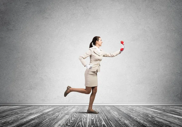 Woman running in room with vintage red phone — 图库照片