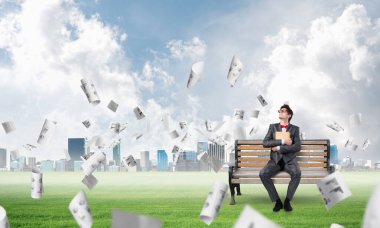 Bankta kitabı olan genç bir öğrenci.