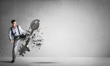 Odada beton anahtarı parçalayan bir adamla erişim kavramını kırmak.