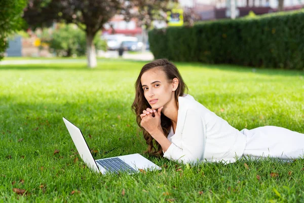 Νεαρή γυναίκα και φορητό υπολογιστή στο πάρκο — Φωτογραφία Αρχείου