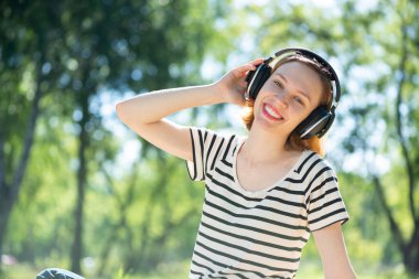 Bir yaz parkında müzik çalan genç bir kadın.