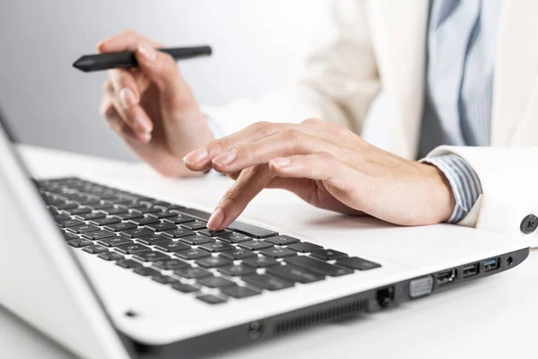 Man in business suit sitting at desk with laptop — Stock Photo, Image