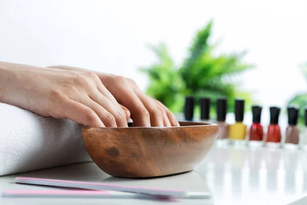 Primo piano mani femminili in ciotola di legno con acqua — Foto Stock