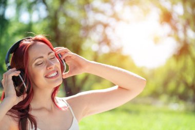 Bir yaz parkında müzik çalan genç bir kadın.