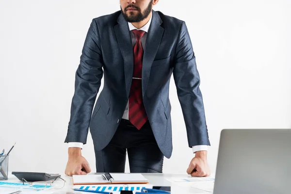 Бизнесмен в костюме и галстуке стоит у стола — стоковое фото