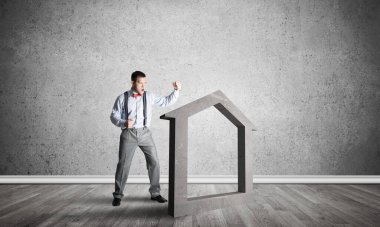 Taştan ev silueti, emlak sigortasının sembolü olarak boş odada.