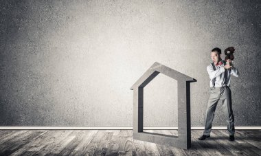 Taştan ev silueti, emlak sigortasının sembolü olarak boş odada.