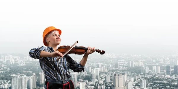 Belle femme en casque de sécurité jouant du violon — Photo