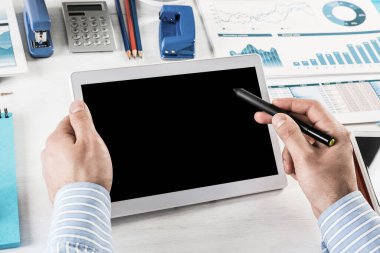 Tabletli bir işadamı, ofiste çalışıyor.