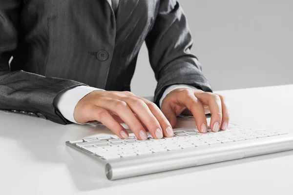 Primer plano de la mujer de negocios escribiendo a mano en el teclado con el ratón en la mesa de madera —  Fotos de Stock