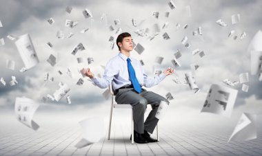 İş adamı ofis sandalyesinde meditasyon yapıyor.