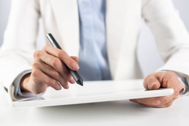 Tablet bilgisayar kullanan takım elbiseli adam.