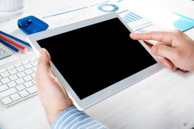 Tabletli bir işadamı, ofiste çalışıyor.