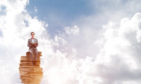 Jovem empresário ou estudante flutuando no céu azul e estudando a ciência — Fotografia de Stock