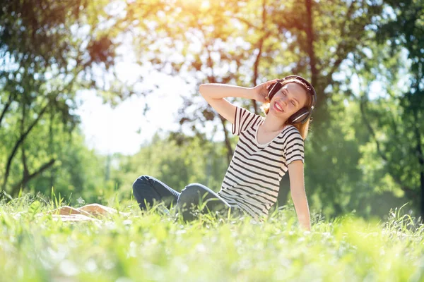 若い女性は夏の公園で音楽を持っていることが起こる — ストック写真