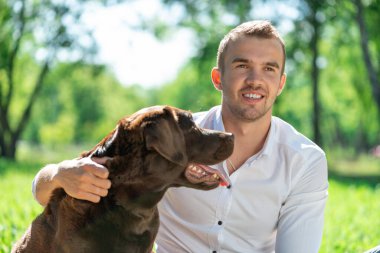 Parkta köpeği olan genç bir adam.