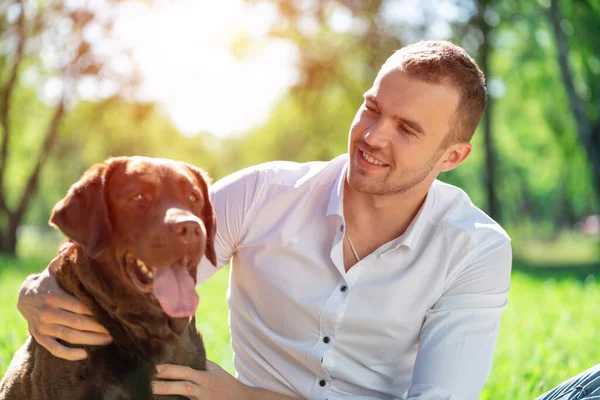 Junger Mann mit Hund im Park — Stockfoto