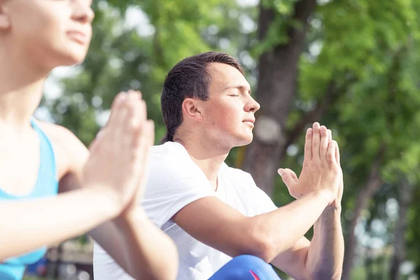 Couple of young sporty people practicing yoga — Stock Photo, Image