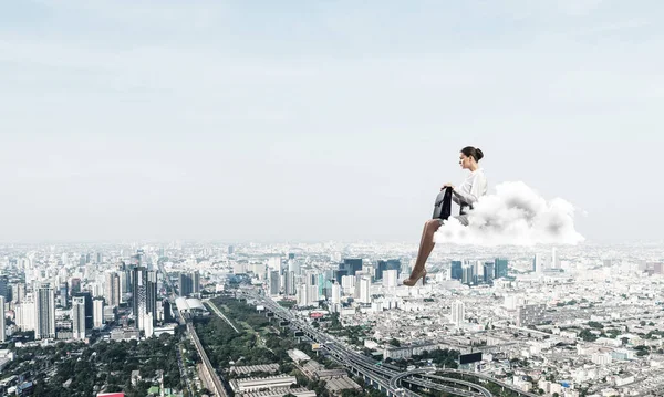 Бізнес-леді або бухгалтер на хмарі, що плаває високо над сучасним містом — стокове фото