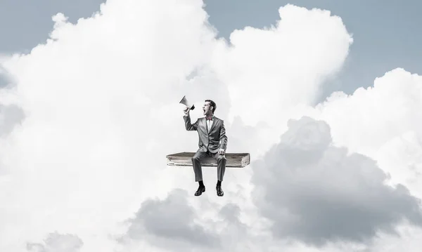 푸른 하늘에 떠 있는 사업가가 확성기로 무엇인가를 발표하는 모습 — 스톡 사진